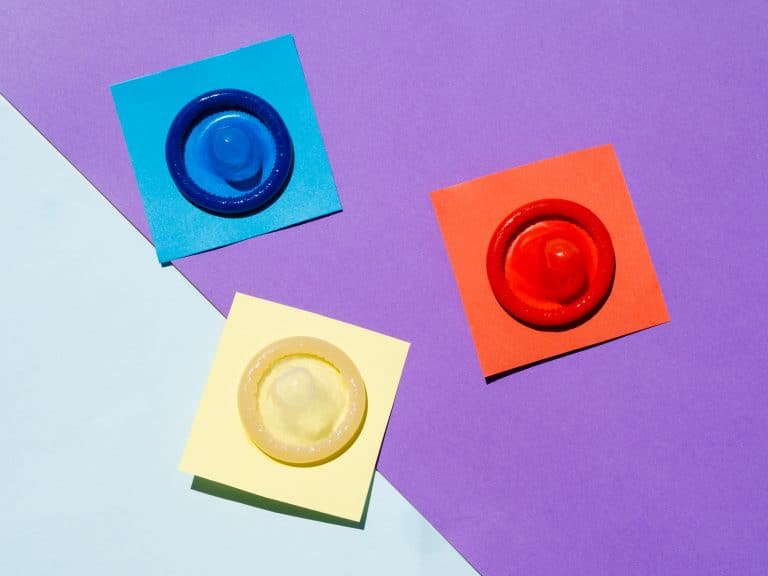 reservativos coloridos sobre fundo vibrante, representando a prevenção de ISTs (Infecções Sexualmente Transmissíveis) e a importância do sexo seguro.