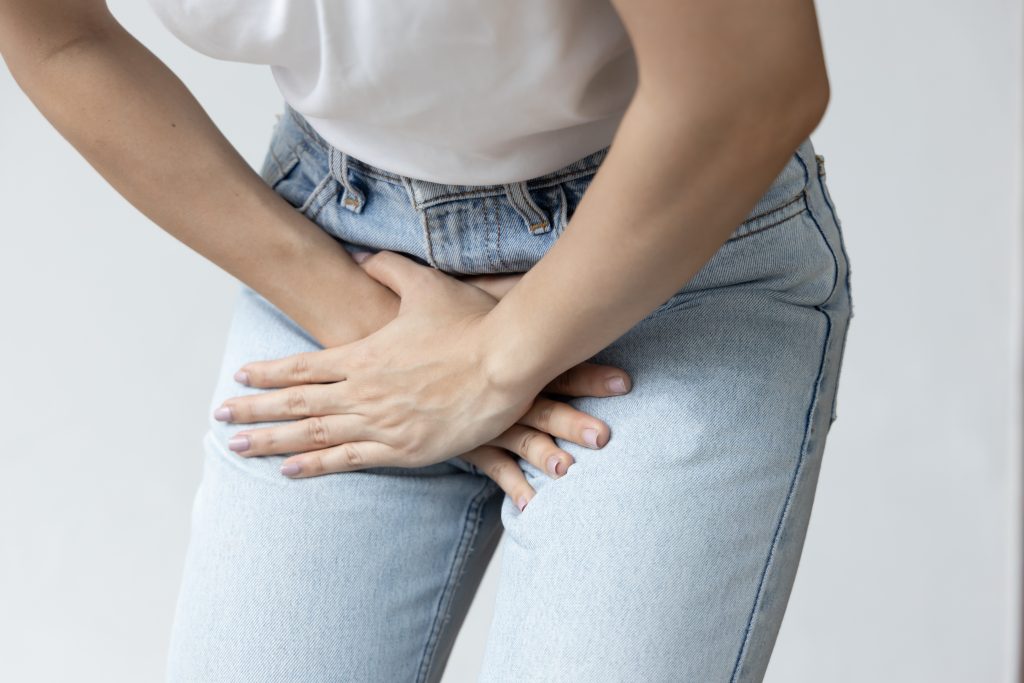 Mulher com desconforto na região abdominal e pélvica, ilustrando sintomas comuns de Infecção urinária.