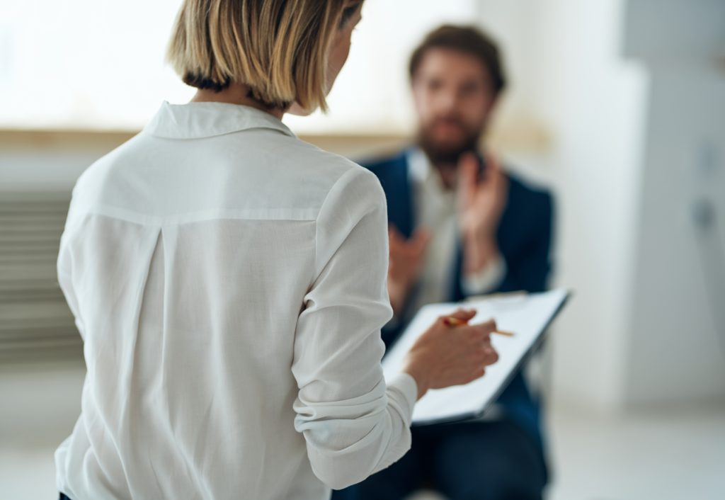 Paciente em consulta com profissional de saúde mental, representando a avaliação de sintomas e acompanhamento psiquiátrico.