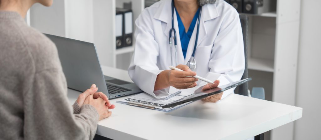 Médica orienta paciente durante consulta, explicando cuidados do pré-operatório e do pós-operatório, destacando medidas importantes para uma recuperação segura e mais rápida.