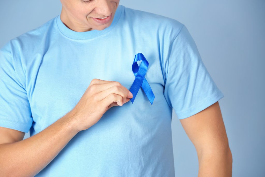 Pessoa usando uma camiseta azul com laço azul no peito, símbolo da conscientização sobre o câncer de próstata, destacando a importância do diagnóstico precoce, dos avanços no tratamento e da qualidade de vida.