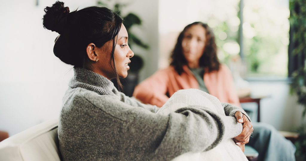 Pessoa conversando com outra mulher em um ambiente acolhedor, representando escuta, apoio emocional e acolhimento diante de pensamentos suicidas.